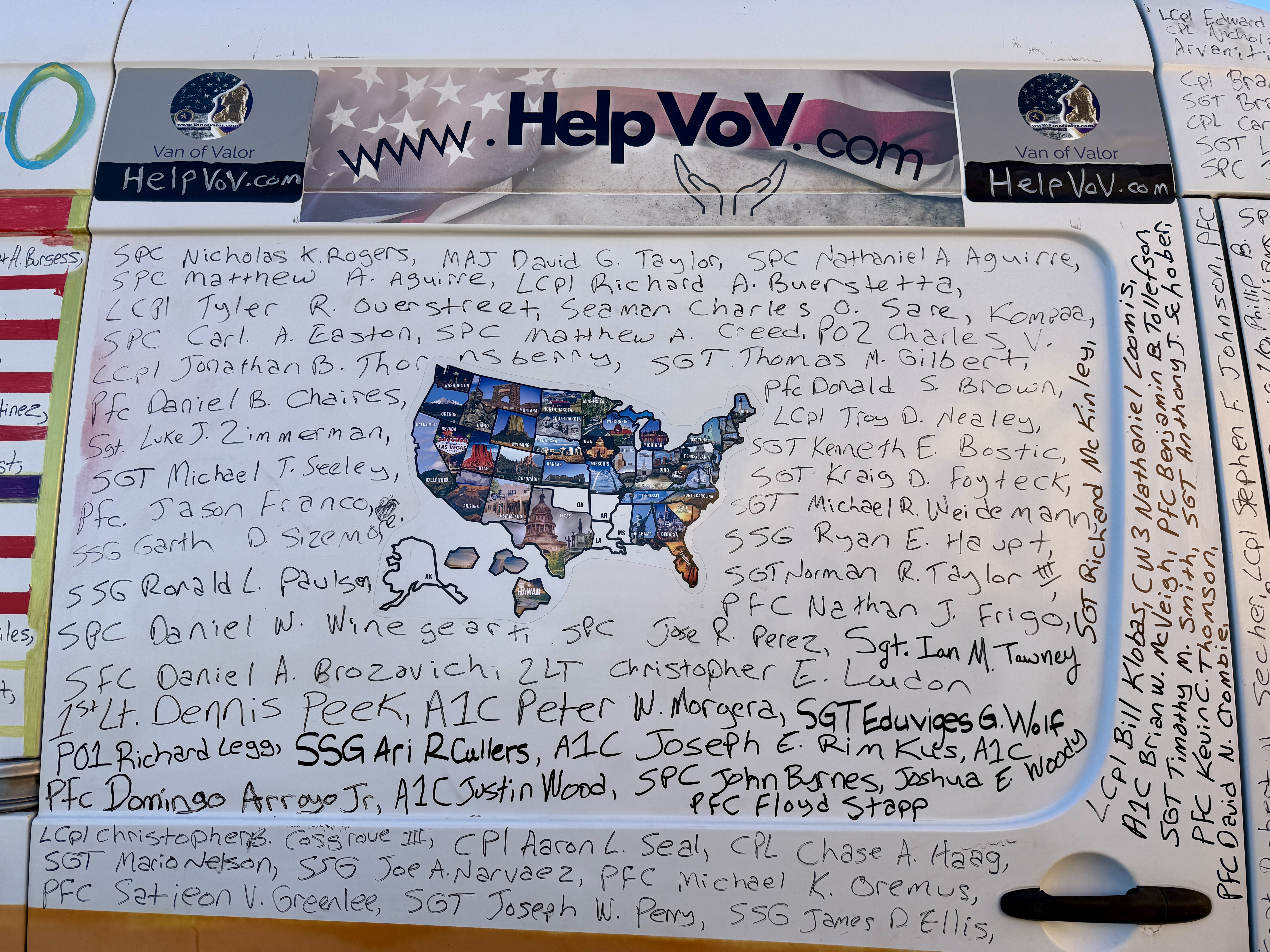 A close-up view of the Van of Valor, showcasing a painted map of the United States along with handwritten names of fallen soldiers, alongside the website HelpVoV.com.